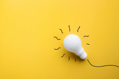 White light bulb with hand-drawn light rays on a yellow background symbolizing a bright idea