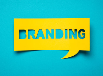 Yellow speech bubble cutout with the word branding on a teal background