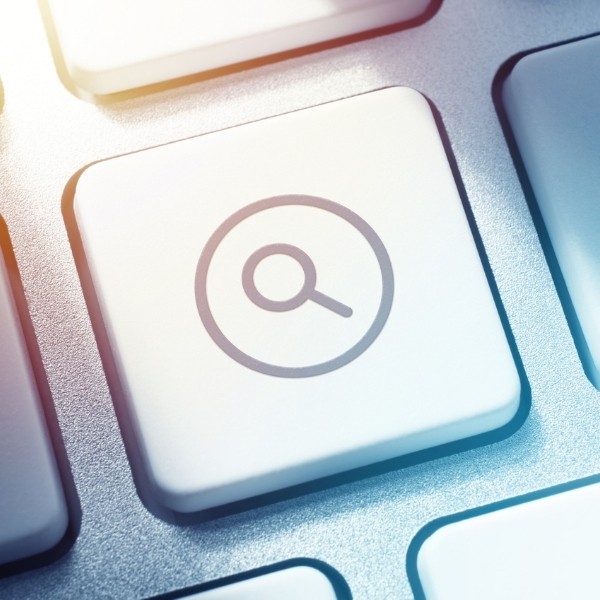 Close-up of a keyboard key with a magnifying glass search icon